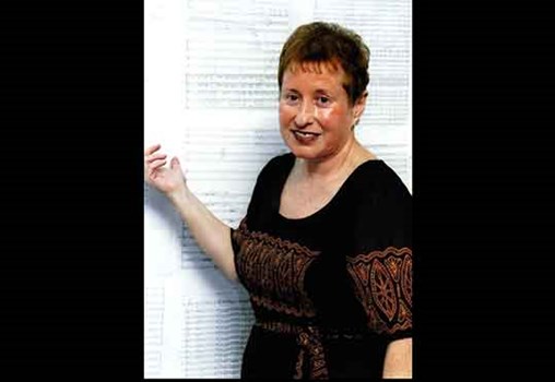 Tsippi Fleischer in front of the score to Symphony No. 5- Israeli-Jewish Collage" at a CD launch event (2004)